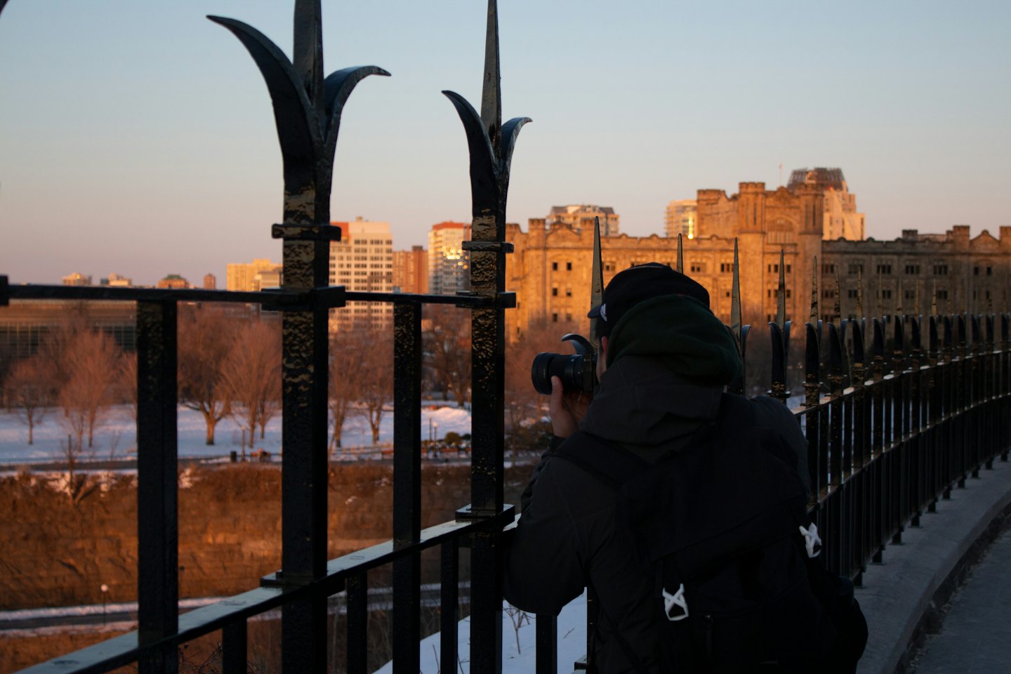Un fotografo con uno zaino scatta foto allo skyline di una città.